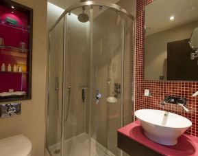 Guest bathroom with shower and free toiletries at Hotel Indigo London Paddington,