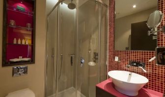 Guest bathroom with shower and free toiletries at Hotel Indigo London Paddington,