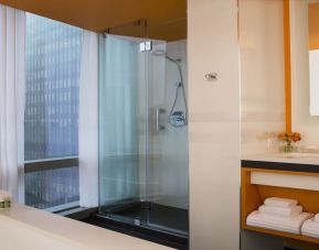 Guest bathroom with shower and tub at Courtyard By Marriott New York Manhattan/Central Park.