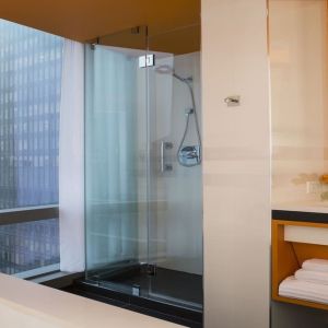 Guest bathroom with shower and tub at Courtyard By Marriott New York Manhattan/Central Park.