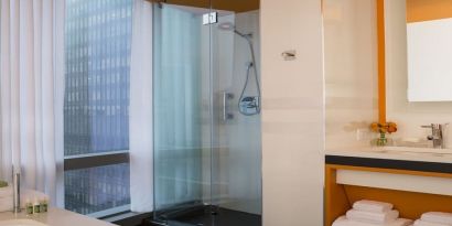 Guest bathroom with shower and tub at Courtyard By Marriott New York Manhattan/Central Park.