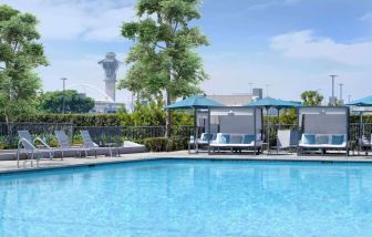 Refreshing outdoor pool with loungers and cabanas at Hyatt Regency Los Angeles International Airport.