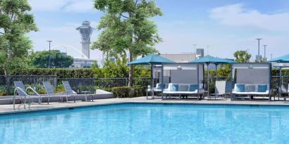 Refreshing outdoor pool with loungers and cabanas at Hyatt Regency Los Angeles International Airport.