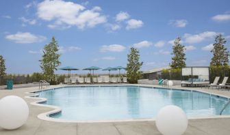 Refreshing outdoor pool with loungers and cabanas at Hyatt Regency Los Angeles International Airport.