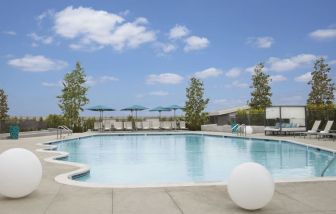 Refreshing outdoor pool with loungers and cabanas at Hyatt Regency Los Angeles International Airport.