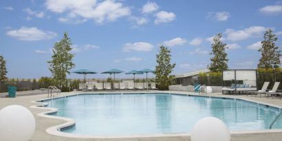 Refreshing outdoor pool with loungers and cabanas at Hyatt Regency Los Angeles International Airport.