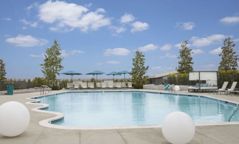 Refreshing outdoor pool with loungers and cabanas at Hyatt Regency Los Angeles International Airport.