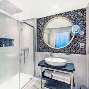 Guest bathroom with shower and free toiletries at Mercure Hotel London Hyde Park.