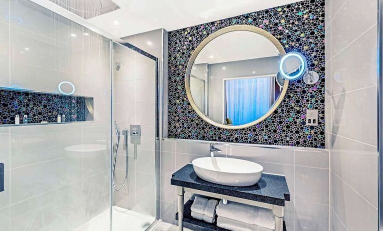 Guest bathroom with shower and free toiletries at Mercure Hotel London Hyde Park.