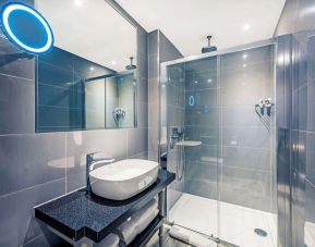 Guest bathroom with shower at Mercure Hotel London Hyde Park.