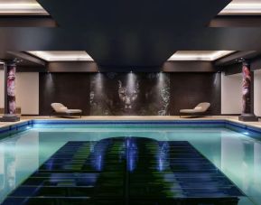 Relaxing indoor pool with lounge chairs at NYX Hotel London Holborn By Leonardo.