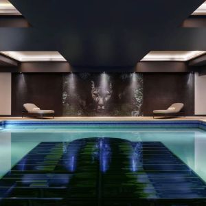 Relaxing indoor pool with lounge chairs at NYX Hotel London Holborn By Leonardo.