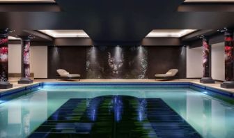 Relaxing indoor pool with lounge chairs at NYX Hotel London Holborn By Leonardo.