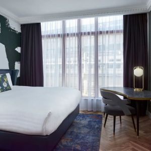 Bright and spacious day use room with king bed, TV screen and work desk at NYX Hotel London Holborn By Leonardo.