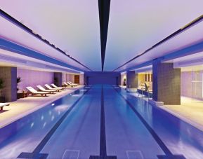 Relaxing indoor pool with lounge chairs at Leonardo Royal Hotel London Tower Bridge.