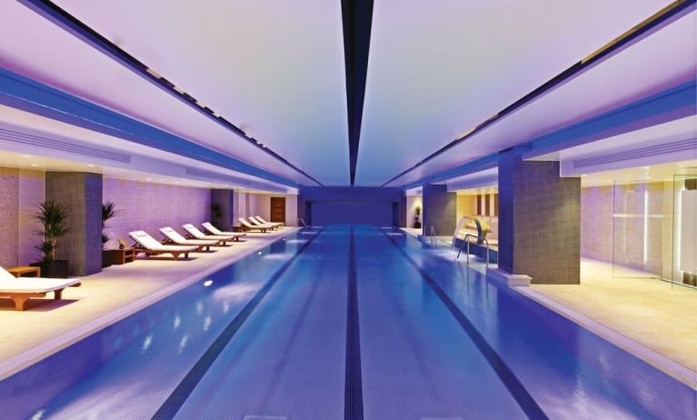 Relaxing indoor pool with lounge chairs at Leonardo Royal Hotel London Tower Bridge.