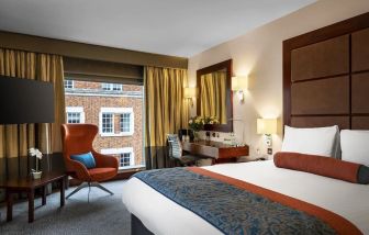 Day use room with work desk, louge seating and floor to ceiling window at Leonardo Royal St Paul's Hotel.