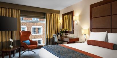 Day use room with work desk, louge seating and floor to ceiling window at Leonardo Royal St Paul's Hotel.