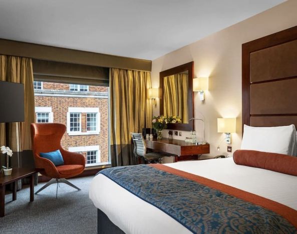 Day use room with work desk, louge seating and floor to ceiling window at Leonardo Royal St Paul's Hotel.