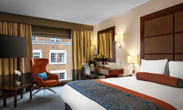 Day use room with work desk, louge seating and floor to ceiling window at Leonardo Royal St Paul's Hotel.