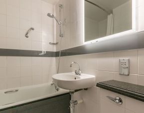 Guest bathroom with combined tub and shower at Thistle Express London, Luton.