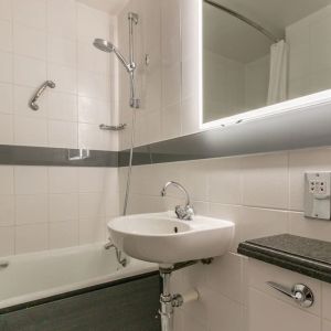 Guest bathroom with combined tub and shower at Thistle Express London, Luton.