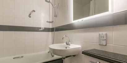 Guest bathroom with combined tub and shower at Thistle Express London, Luton.