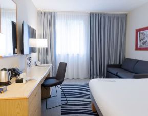 Day use room with work desk, TV screen and sofa at Novotel Manchester West.