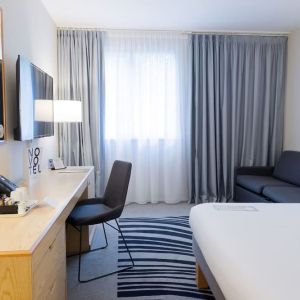 Day use room with work desk, TV screen and sofa at Novotel Manchester West.