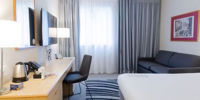 Day use room with work desk, TV screen and sofa at Novotel Manchester West.