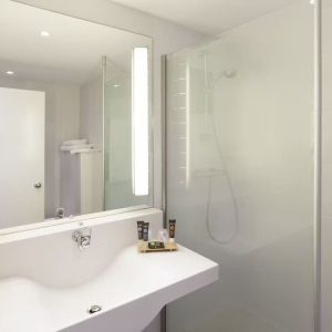 Private guest bathroom with free toiletries at Novotel Manchester West.