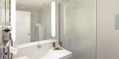 Private guest bathroom with free toiletries at Novotel Manchester West.