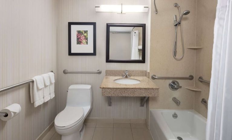 Guest bathroom with shower and tub at Hilton Garden Inn Queens/JFK Airport.