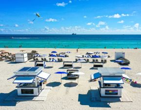 On the beach with ample sun loungers at The Sagamore Hotel South Beach.