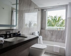 Guest bathroom with shower and tub at The Sagamore Hotel South Beach.