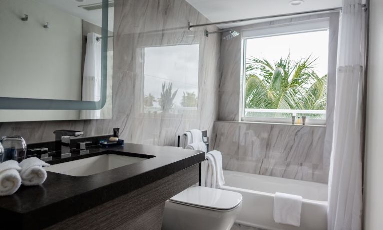 Guest bathroom with shower and tub at The Sagamore Hotel South Beach.