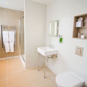 Guest bathroom with shower and free toiletries at The Wesley Euston Hotel.