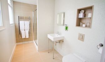 Guest bathroom with shower and free toiletries at The Wesley Euston Hotel.