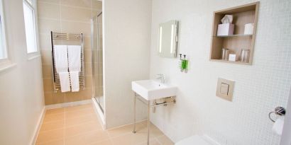 Guest bathroom with shower and free toiletries at The Wesley Euston Hotel.