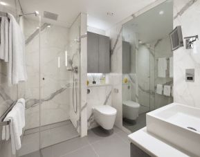 Guest bathroom with shower and free toiletries at Tower Suites By Blue Orchid Hotels.