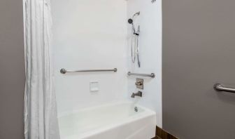 Guest bathroom with combined tub and shower at Hotel 1550 SFO.