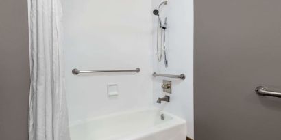 Guest bathroom with combined tub and shower at Hotel 1550 SFO.