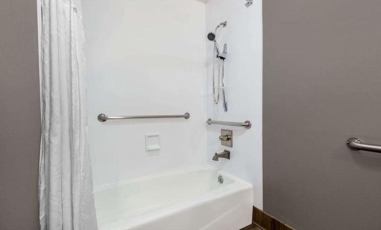 Guest bathroom with combined tub and shower at Hotel 1550 SFO.