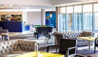 Hotel bar with lounge seating and billiards at Ibis Styles Barnsley.