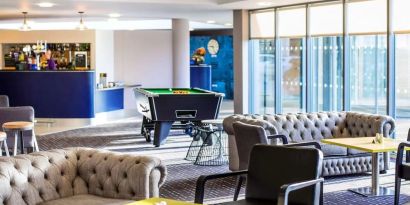 Hotel bar with lounge seating and billiards at Ibis Styles Barnsley.