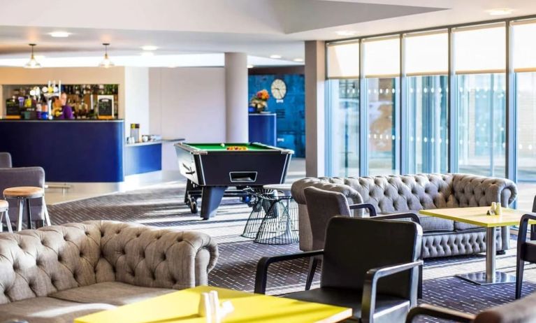 Hotel bar with lounge seating and billiards at Ibis Styles Barnsley.