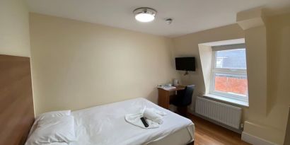 Standard day use room with TV screen and work desk at Buckingham Hotel.