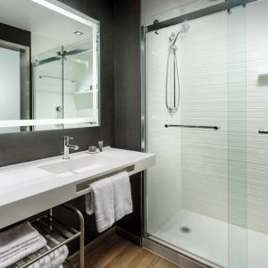 Guest bathroom with shower at AC Hotel By Marriott SFO/Oyster Point Waterfront.