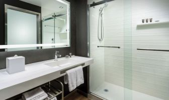 Guest bathroom with shower at AC Hotel By Marriott SFO/Oyster Point Waterfront.