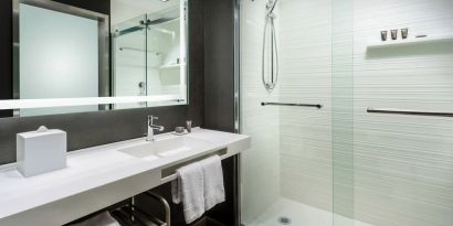 Guest bathroom with shower at AC Hotel By Marriott SFO/Oyster Point Waterfront.